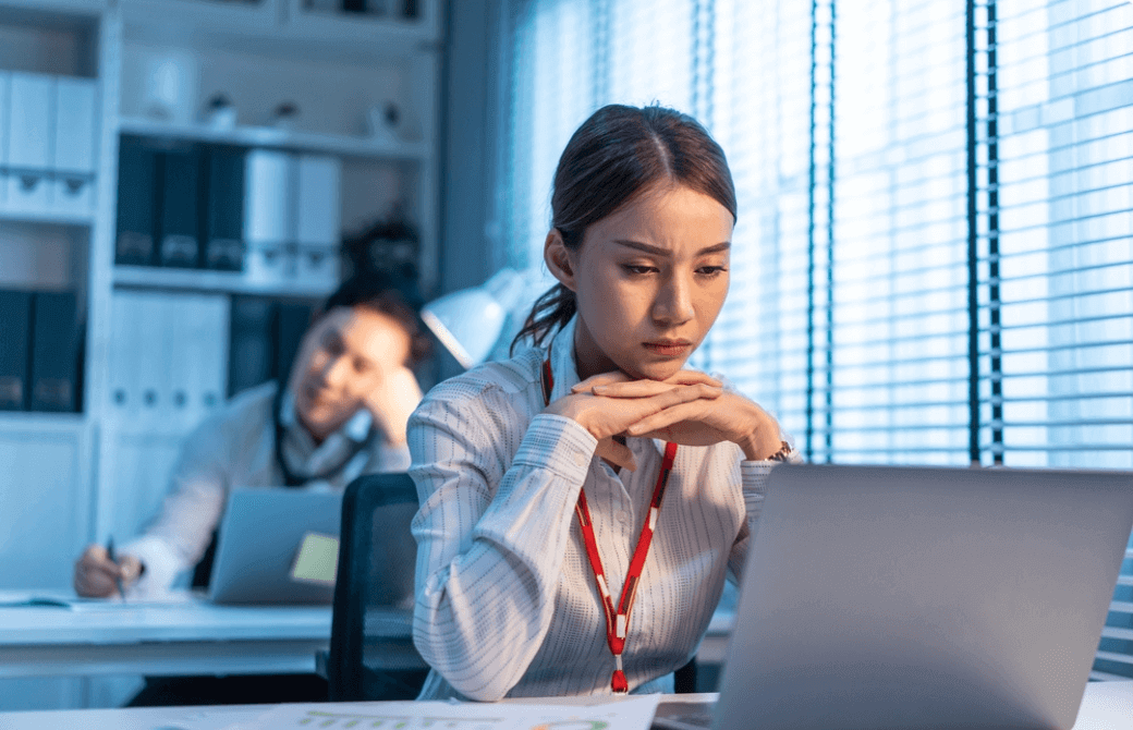 暗い表情でパソコンに向かう女性