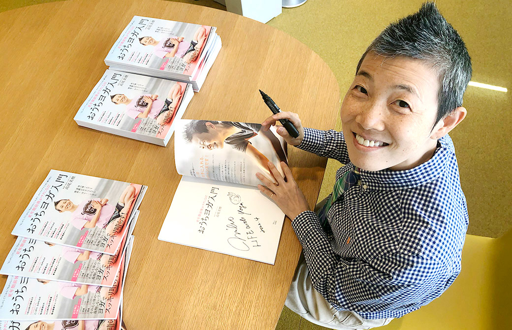 高尾先生が本にサインをしている様子