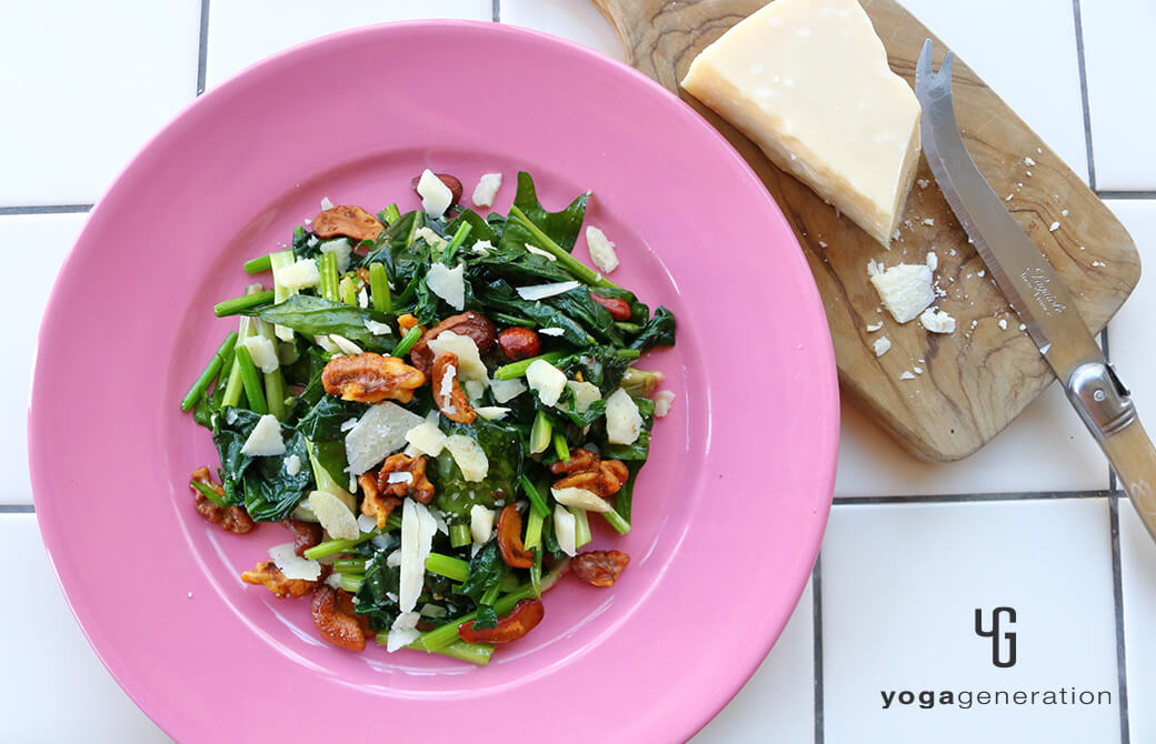 ピンクのお皿に盛り付けたホウレン草とスパイシーナッツのホットサラダ