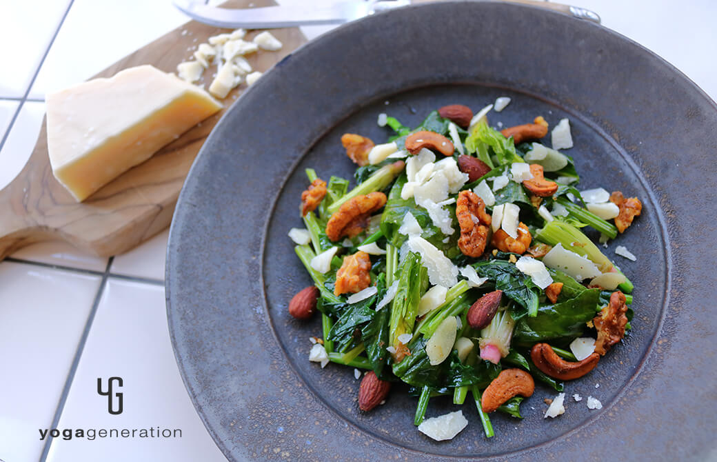 黒いお皿に盛り付けたホウレン草とスパイシーナッツのホットサラダ