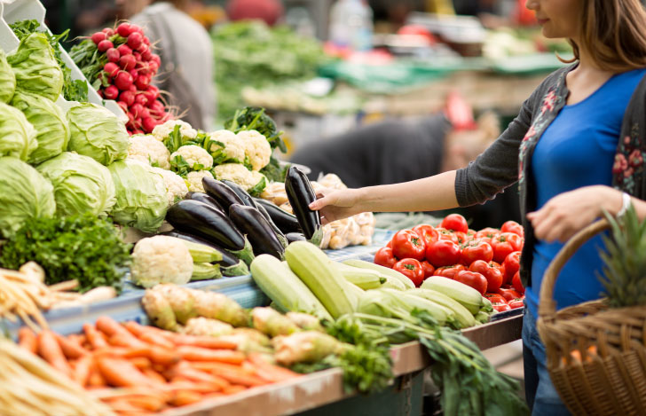 オーガニックマーケットで野菜を選ぶ女性の手元