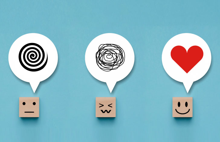 四角い木製のキューブに描かれた人の顔と感情を表す吹き出し