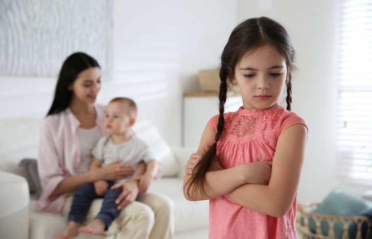 弟が母親に抱かれていることに嫉妬する少女