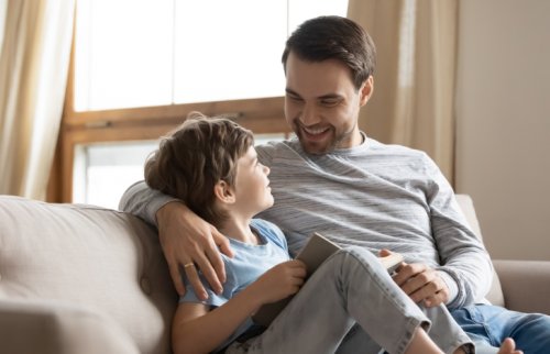 部屋の中で本を見ながら話す父と男の子