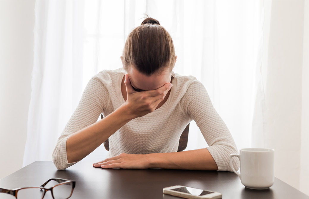 手で顔を覆う女性