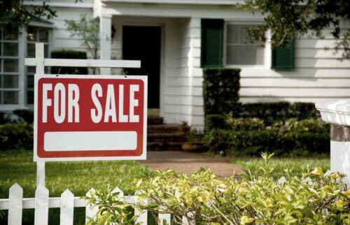 売り家の張り札が掲げられた白い家