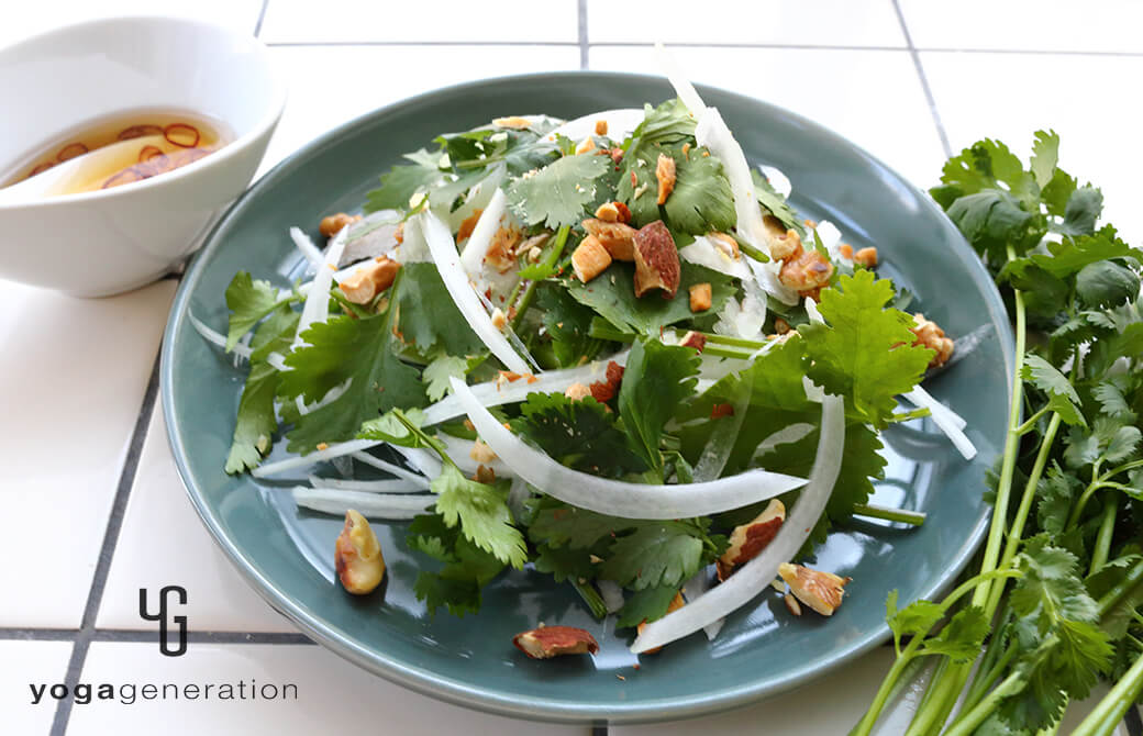 ブルーグレーのお皿に盛り付けた新タマネギとパクチーのアジアン・ナッツサラダ