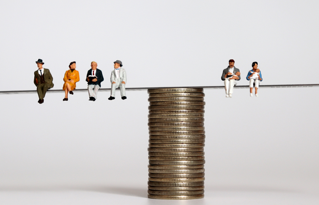 コインのシーソーの上に乗るミニチュア人形