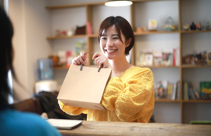 紙袋を受け取る女性