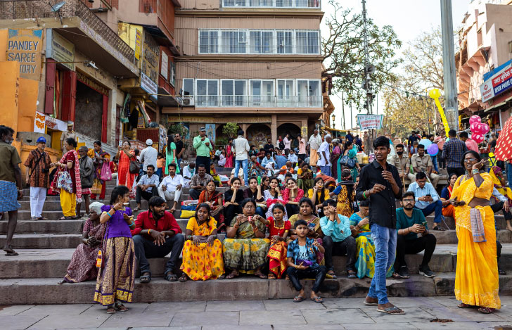 インドの街の中の階段に座るろうなく男女様々な人