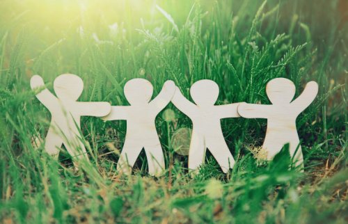 芝生の上で手をつなぐ白い人形