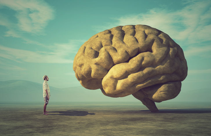 地上に聳え立つ大きな脳とそれを見上げる小さな人
