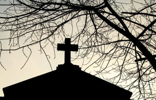 夕暮れに浮かぶ十字架のある建物