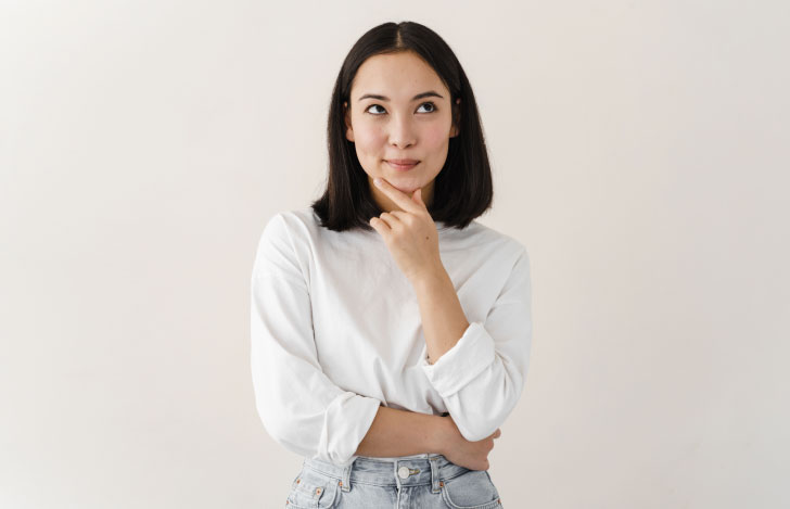手を顎に当てて考える女性