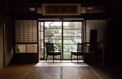 窓際に椅子が置かれた古民家の一室