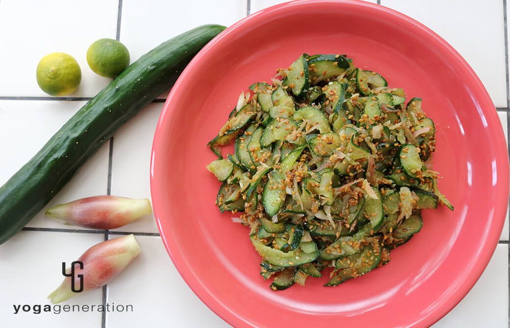 赤みのあるピンク色のお皿に盛り付けたキュウリとミョウガのたっぷり金ゴマ柚子胡椒