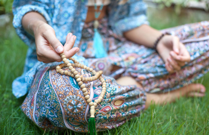 安楽座で座る右手にマーラーを持つ女性の半身