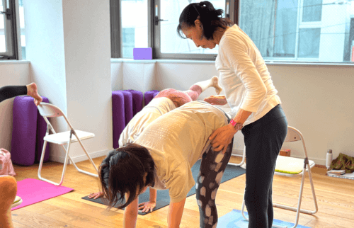 生徒のポーズを補助する柳生直子先生