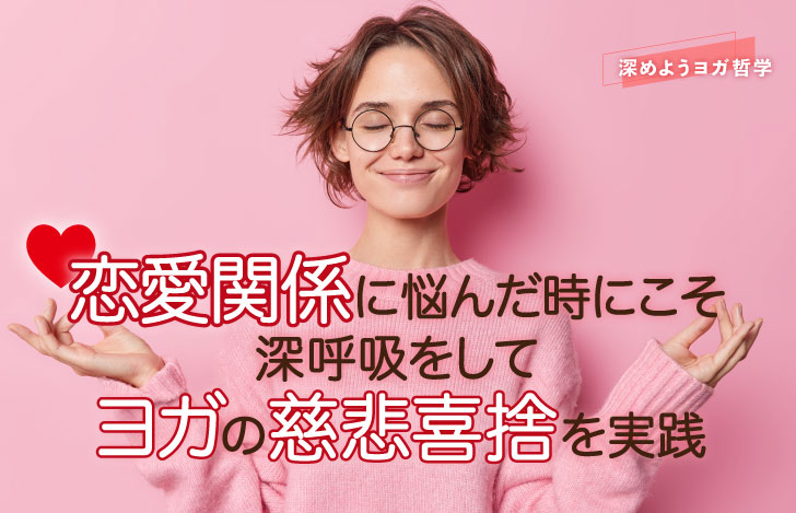 両手でチンムドラを組み、目を閉じて微笑むピンク色のセーターを着た女性