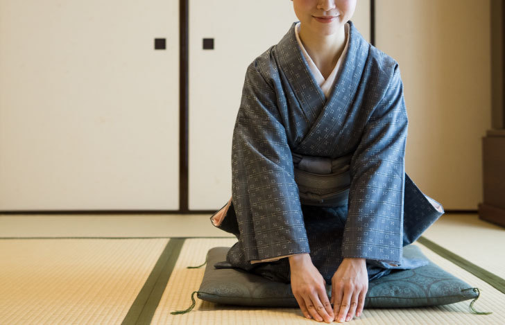 着物をきて床に手をつく女性