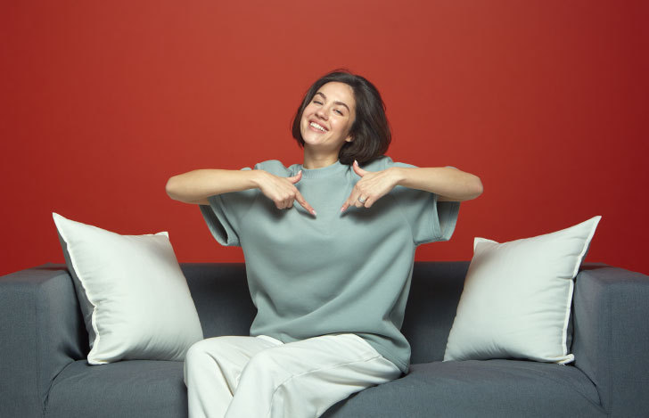 自分の心を指さす女性