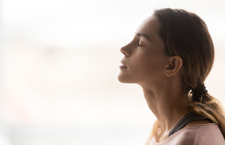 目を閉じて顎を上げる女性の横顔