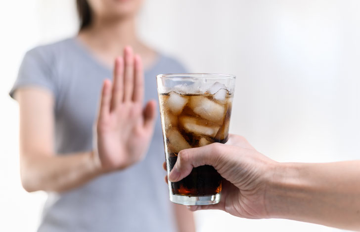 ジャンクフードや炭酸飲料などの不健康な食べ物を拒否する人の手