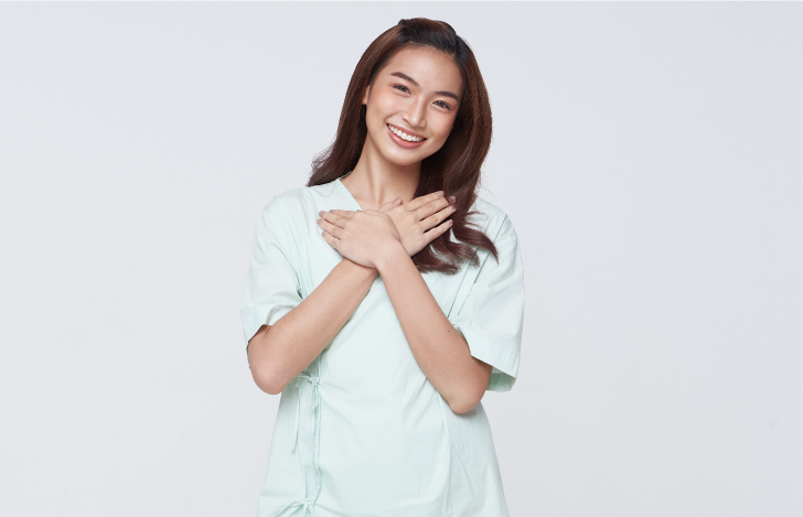 胸に手を当ててほほ笑む女性