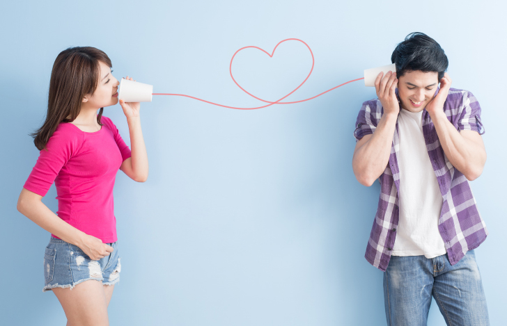 糸電話で電話しているカップル