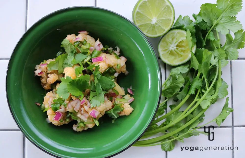 緑の器に盛り付けたカリフラワーのメキシカンサラダ
