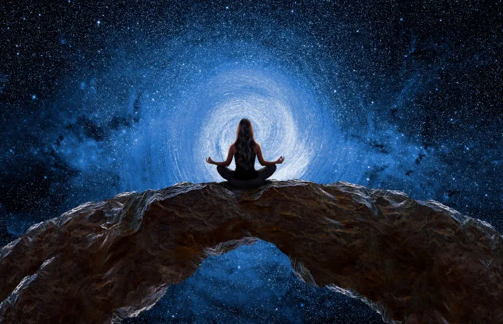 宇宙のイメージ映像を背景とした大地に座る女性のシルエット