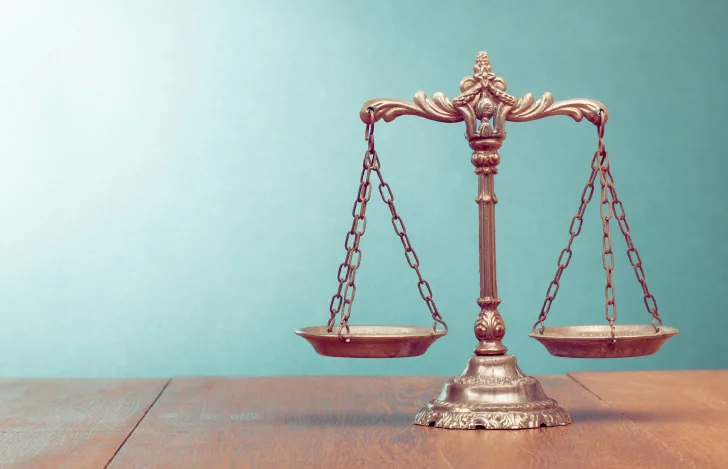 天秤の置物とブルーの壁