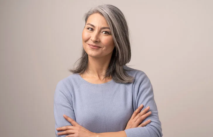 ブルーグレーのニットを着た白髪の女性