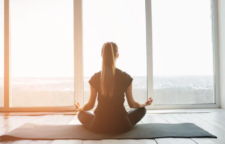 窓に向かって安楽座で座る女性の後ろ姿