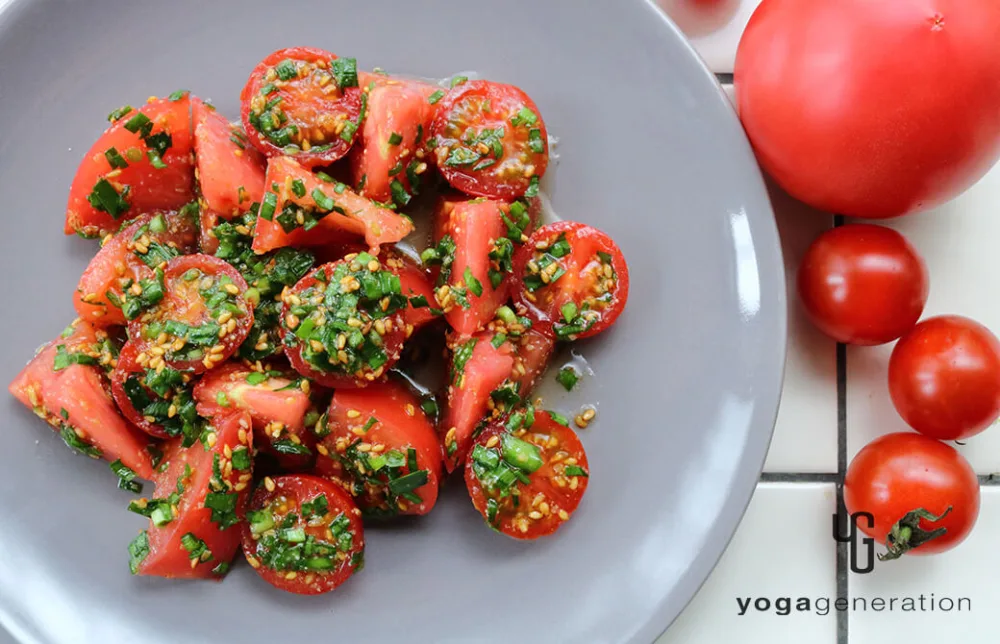 グレーのお皿に盛り付けたゴマ香るトマトとニラのナンプラーマリネ