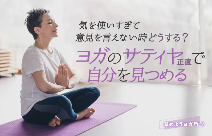 室内のヨガマットの上で瞑想する短髪の女性