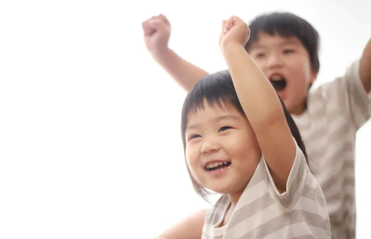 手を挙げる笑顔の子供達