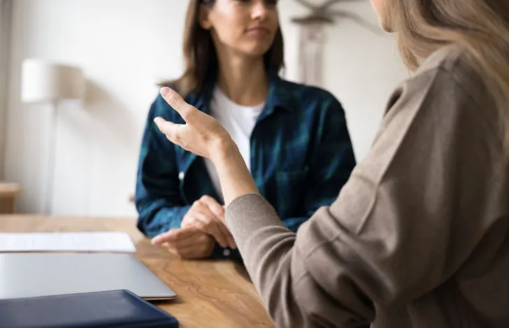 机の前で話す2人の女性