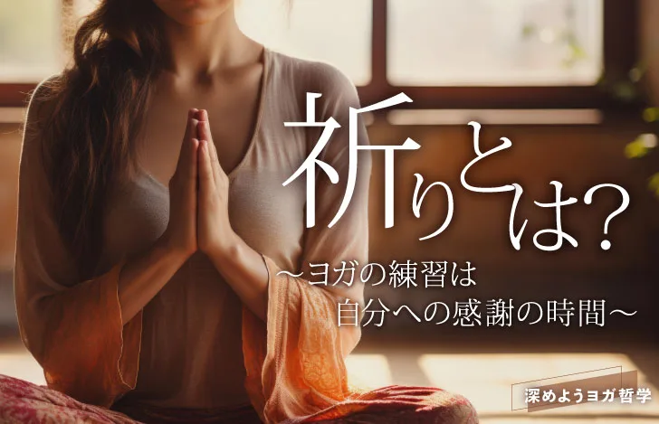 室内でゆったりとしたヨガウェアをまとい胸の前で手を合わせる女性の手元