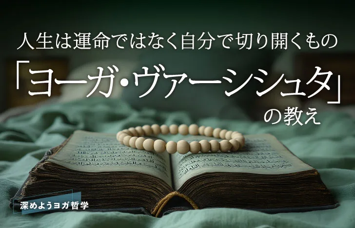 グリーンの布の上に開かれた状態で置かれた古い本と数珠