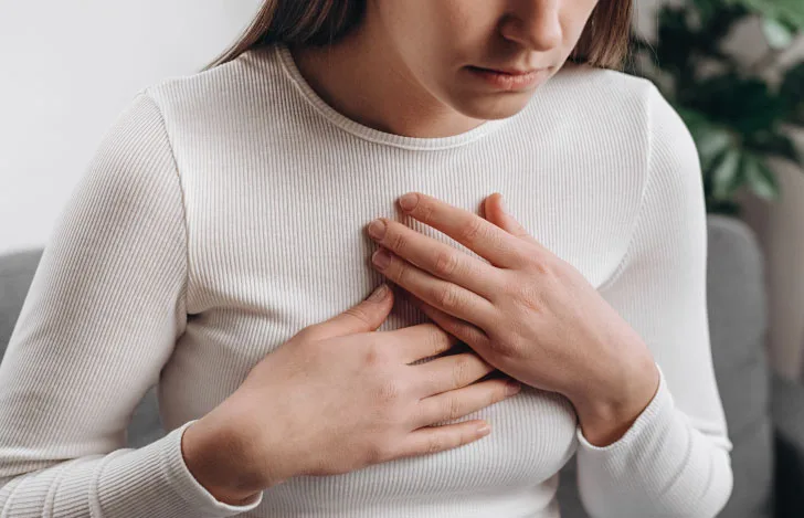両手で胸を押さえる女性