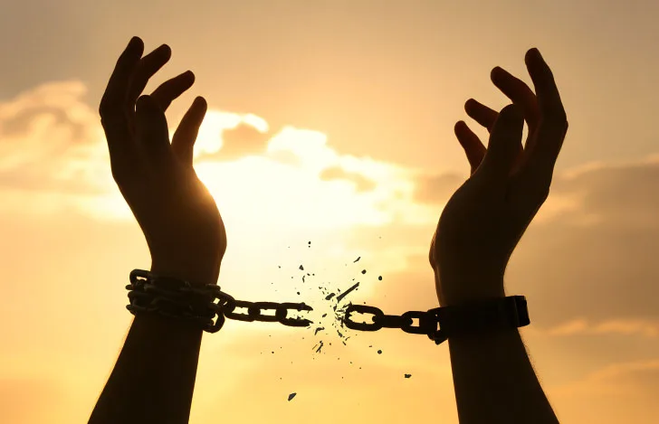 繋がれた鎖をちぎるてのシルエット