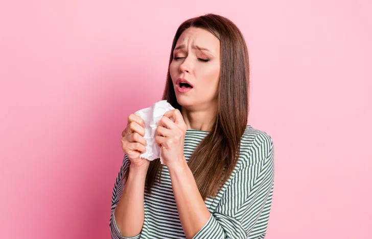ティッシュを手にくしゃみをしそうになっている女性