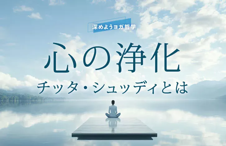 静かな水面を見渡す座った女性の背中