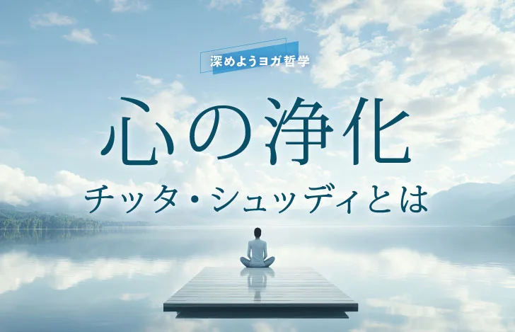 静かな水面を見渡す座った女性の背中