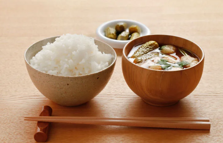 白いご飯と味噌汁とお漬物と箸置きに置かれた箸
