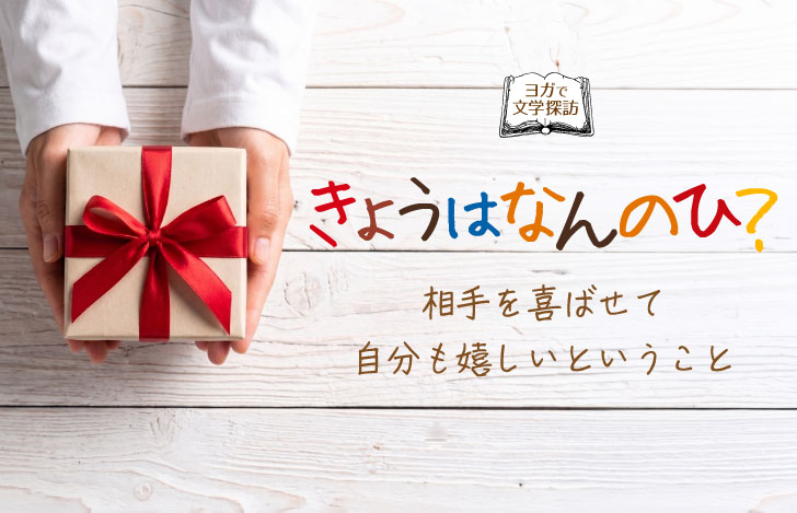 白いのテーブルの上で赤いリボンがかかった箱を手にする女性の手元