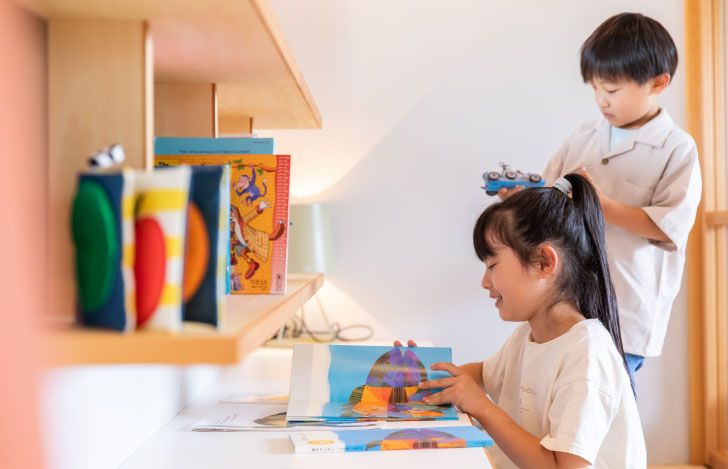 本棚の前で絵本を読む子供たち